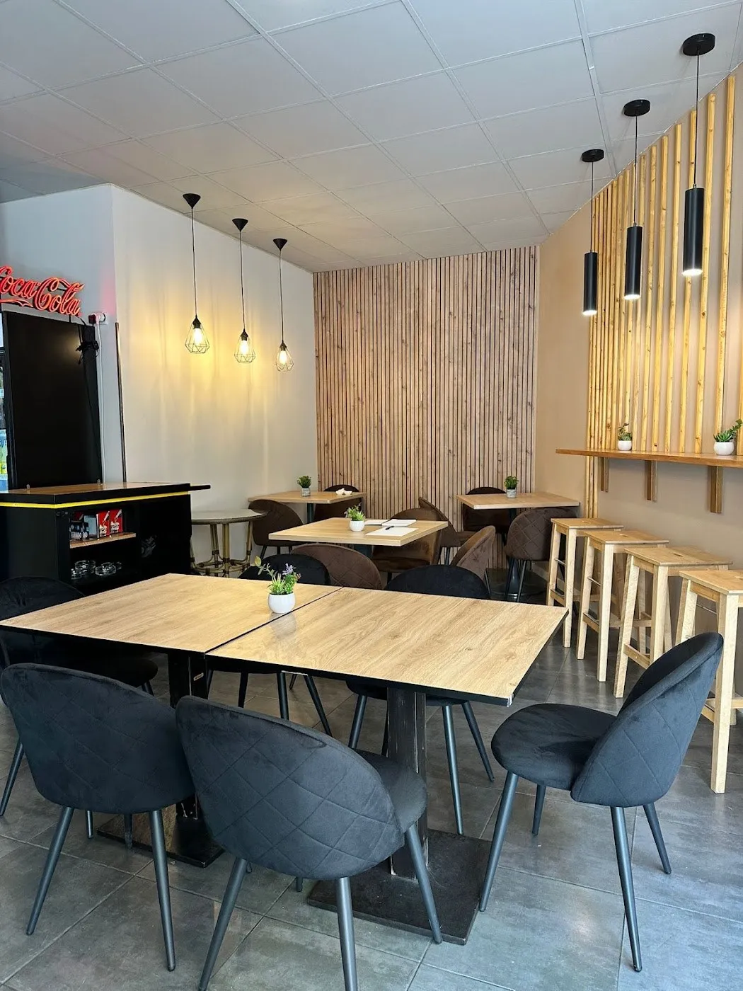 Comedor con mesas de madera y lámparas colgantes