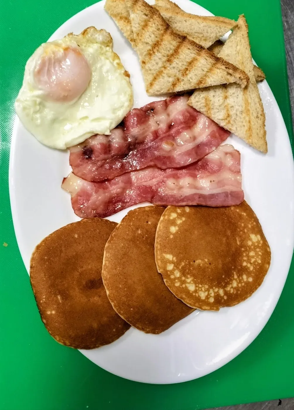Tortitas con bacon, huevo frito y pan tostado