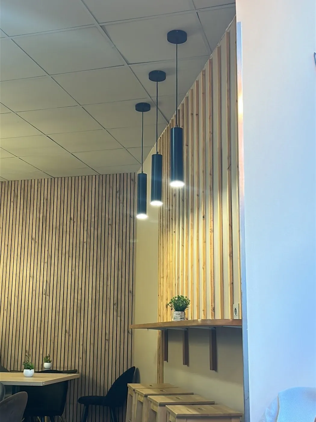 Barra de madera con taburetes junto a la pared